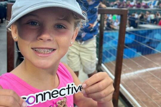 Picture of a child holding up a Connective sticker